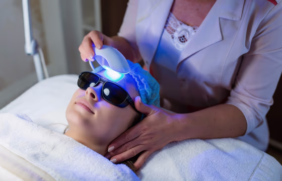 Cliente deitada recebendo fototerapia com luz azul LED e proteção ocular